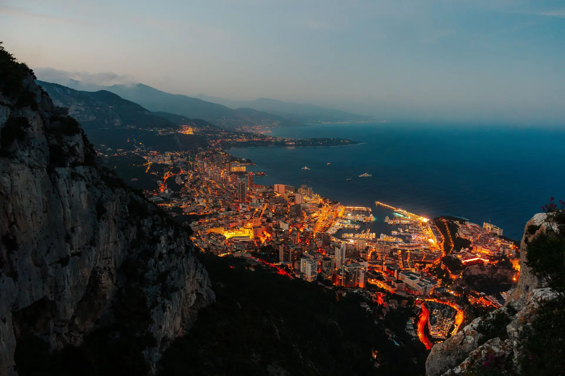 Panoramisk nattutsikt over Monte Carlos opplyste havn og luksusyachter