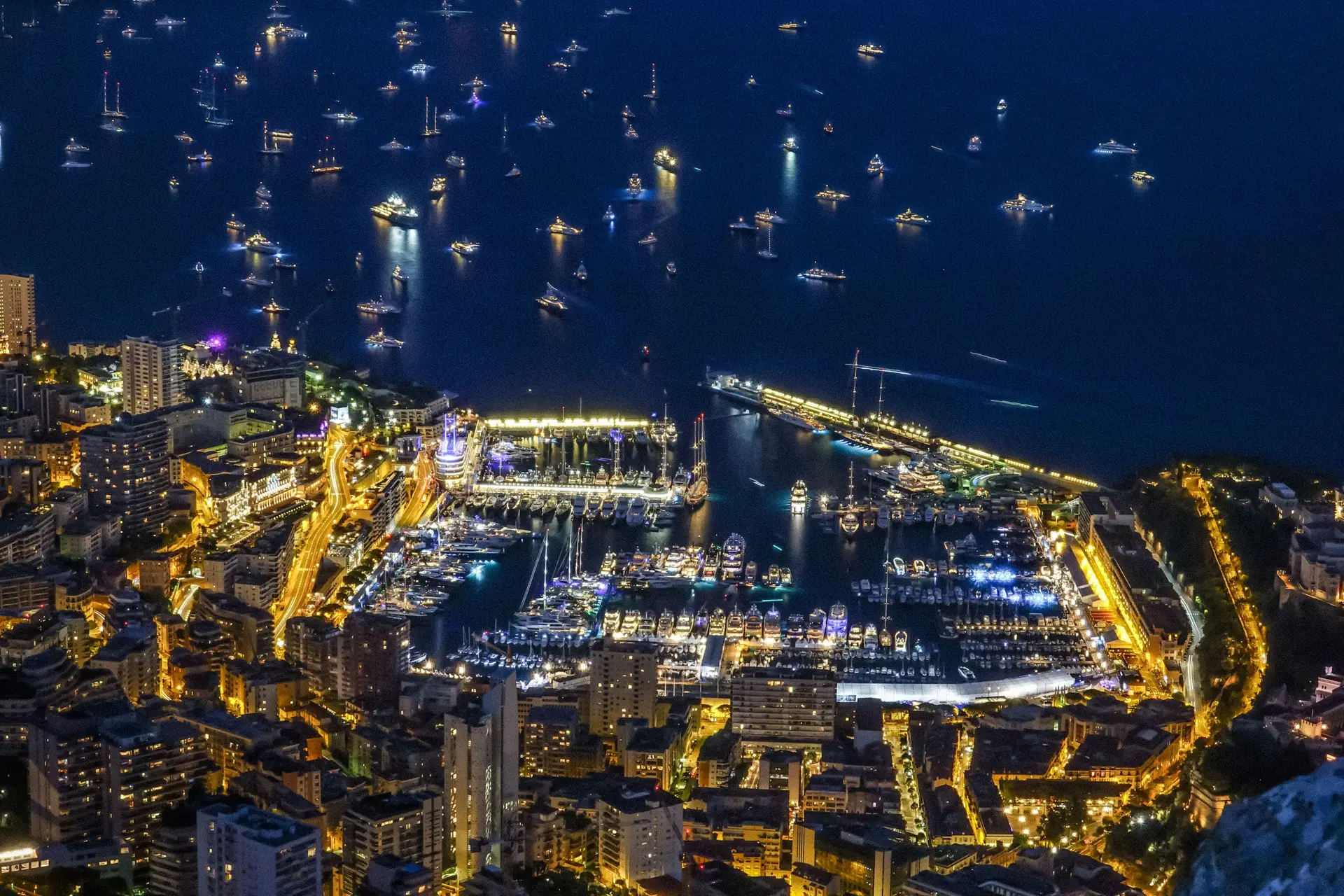 Panoramakveld over Monte Carlo havn og opplyste luksusyachter